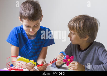 Two boys creating with 3d printing pens Stock Photo - Alamy