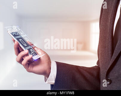 Businessman holding smart phone with media icons. Stock Photo