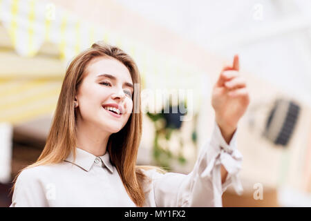 Young beautiful smiling girl pointing on something Stock Photo