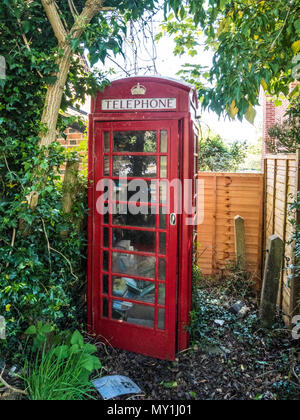 An old red telephone box used as a book swap location in a Wiltshire village. Stock Photo