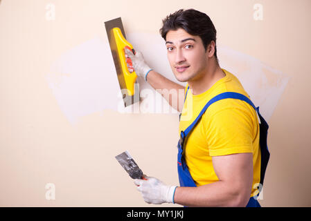 Young contractor employee applying plaster on wall Stock Photo