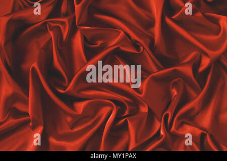 Close up of ripples in red silk fabric. Satin textile background. Stock Photo