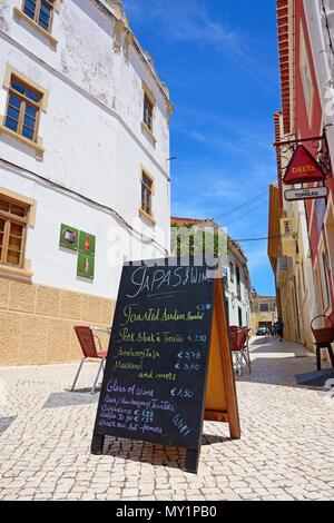 Tapas menu board on the pavement outside a cafe along Rua da Porta de Loule in the old town, Silves, Portugal, Europe. Stock Photo