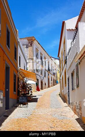 View along an old town cobbled street (Rua da Se) with a tourist gift shop on the left hand side, Silves, Portugal, Europe. Stock Photo