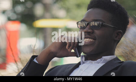 Handsome african american man laughs and talks on his cell phone Stock Photo