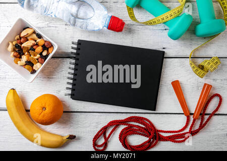fitness equipment and nutrition on white wooden background with blank notebook Stock Photo