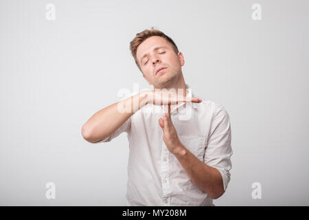Young caucasian man tired and bored, making a timeout gesture. Stock Photo