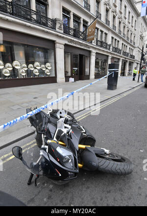 A bike on its side outside Watches of Switzerland on London's Regent Street after raiders on scooters armed with knives and hammers entered the store and stole several items of property. Stock Photo