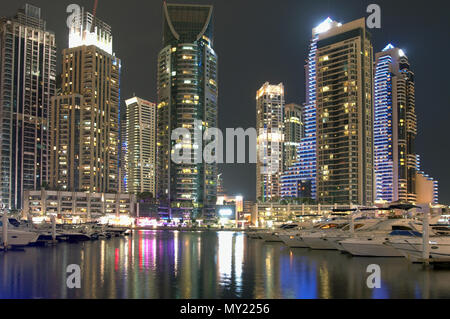Dubai, United Arab Emirates - May  26, 2018.  High skyscrapers of the business city centers, located near the seaport.  Night time urban landscape Stock Photo