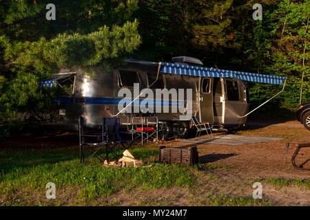 The iconic American made Airstream travel trailer sits in at a campsite at Driftwood Provincial Park in Ontario Canada. Airstream was founded in the l Stock Photo