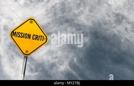 Mission Critical - yellow sign with cloudy sky Stock Photo