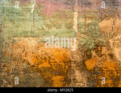 Grunge old wall texture background. Layers of paint cracking off wall with rust underneath Stock Photo
