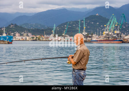 Batumi, Georgia - August 25, 2017: People fishing from the pier on the center of Batumi. Stock Photo