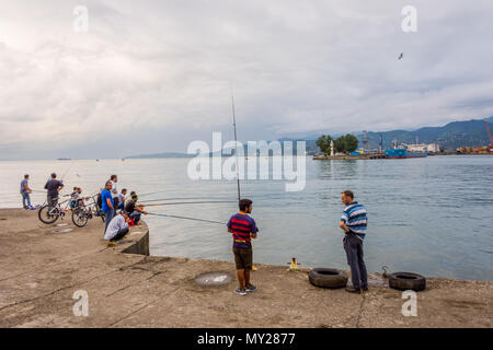 Batumi, Georgia - August 25, 2017: People fishing from the pier on the center of Batumi. Stock Photo