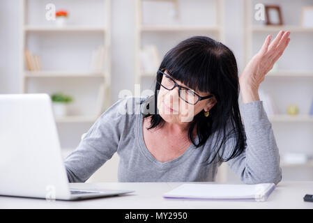 Senior woman struggling at computer Stock Photo