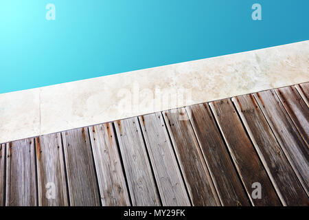 Minimalist close up view of a swimming pool and the wooden flooring of its deck Stock Photo
