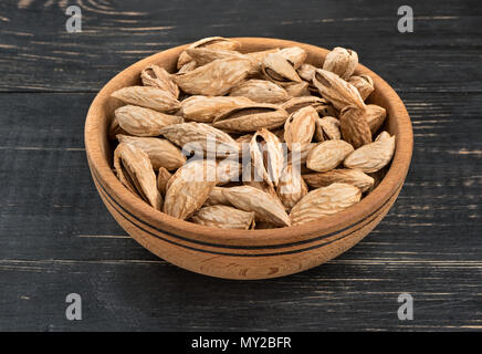 Uzbek inshell almonds in a bowl on wooden background Stock Photo