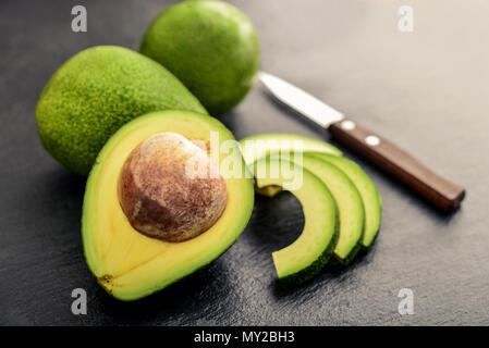 Fresh avocado over black slate background Stock Photo