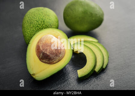 Fresh avocado over black slate background Stock Photo