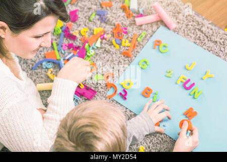 Young boy learning letters during a session with speech therapist Stock Photo