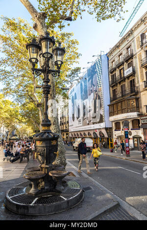 Barcelona, Spain - September 20, 2017: Font de Canaletes, ornate fountain crowned by a lamp post, with people walking around in Les Rambles of Barcelo Stock Photo