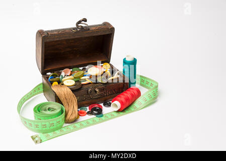 Small wooden box with buttons and threads on a white background Stock Photo