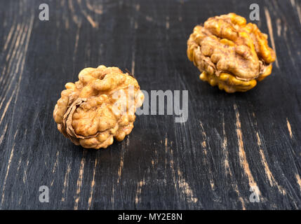 Two walnuts without shell on wooden background closeup Stock Photo