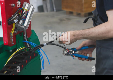 Work of electrician engineer - switching and testing equipment with wires Stock Photo