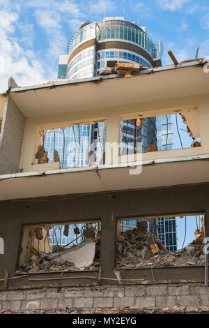 View of the shell of a demolished building with a modern office building sited in the background, Warsaw, Poland. Stock Photo
