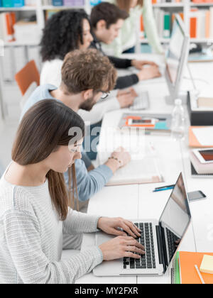 Young office workers and students at the coworking space, they are studying and connecting online using computers Stock Photo