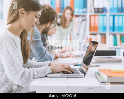 Young office workers and students at the coworking space, they are studying and connecting online using computers Stock Photo
