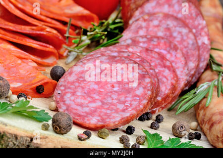 Sliced of salami with sausages on a wood table close up Stock Photo