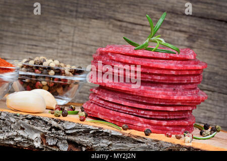 Sliced of salami with spices on cutting board close up Stock Photo