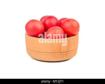 Small wooden bowl of red cherry plums isolated on a white background Stock Photo