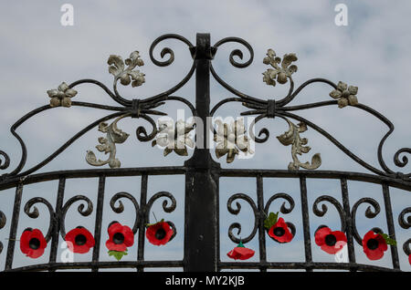 Rhyl, UK: June 3, 2018: Artificial poppies attached to The Garden of Remembrance entrance gates, Rhyl. It is dedicated to soldiers from Rhyl who gave  Stock Photo