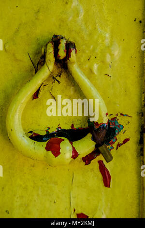 Yellow & Red paint peeling on a old wooden door Stock Photo