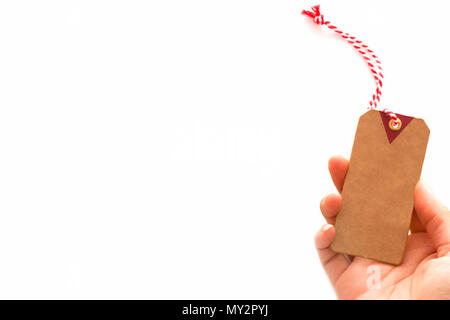 Closeup of hands holding old brown paper tag or label, cardboard price tag on white background. Stock Photo