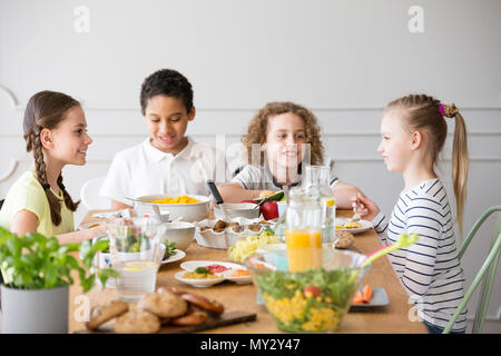 Smiling kids eating dinner while celebrating children's day at home Stock Photo