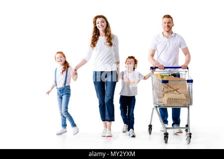 happy young family with two kids walking with shopping trolley isolated on white Stock Photo