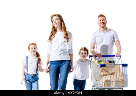 happy young family holding hands and walking with shopping trolley isolated on white Stock Photo