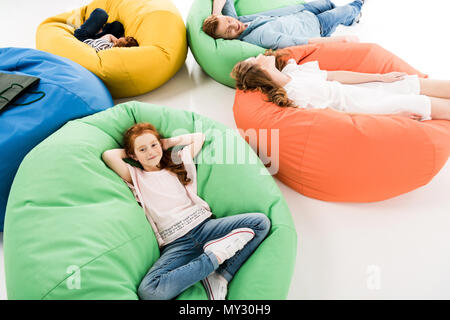 high angle view of happy family with two kids resting on bean bag chairs after shopping Stock Photo