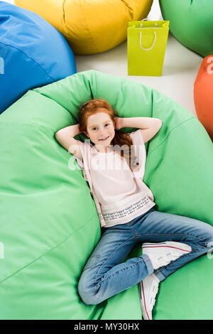 Girl lying on a bean bag and using a digital tablet Stock Photo - Alamy