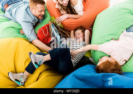 high angle view of happy family with shopping bags having fun on bean bag chairs Stock Photo