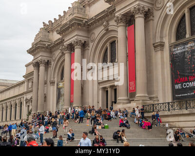NEW YORK, NY – MAY 18, 2018: Museum goers and tourists rest outside on the steps of the The Met (The Metropolitan Museum of Art). Stock Photo