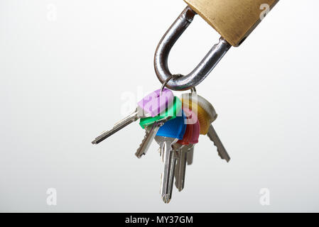 Keys hanging on metal lock isolated on white background close-up view Stock Photo