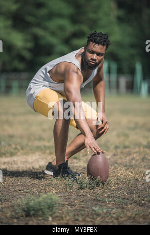 young handsome african american male football player with ball on court Stock Photo