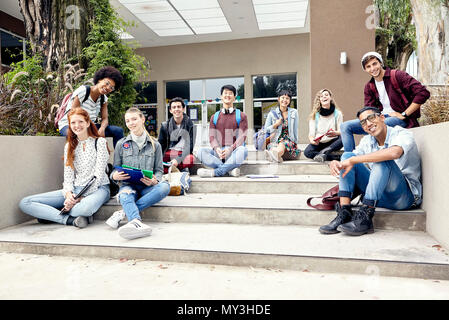 College students sitting on steps outside building, portrait Stock Photo