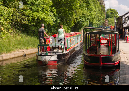 Canal narrowboat passing the old wharf in Llangollen now converted to tea rooms and the terminus for horse drawn narrow boat cruise trips Stock Photo