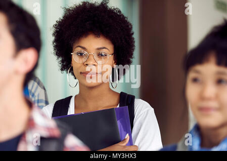 Female college student smiling in corridor, portrait Stock Photo
