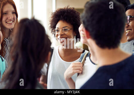 Students chatting together in school corridor Stock Photo